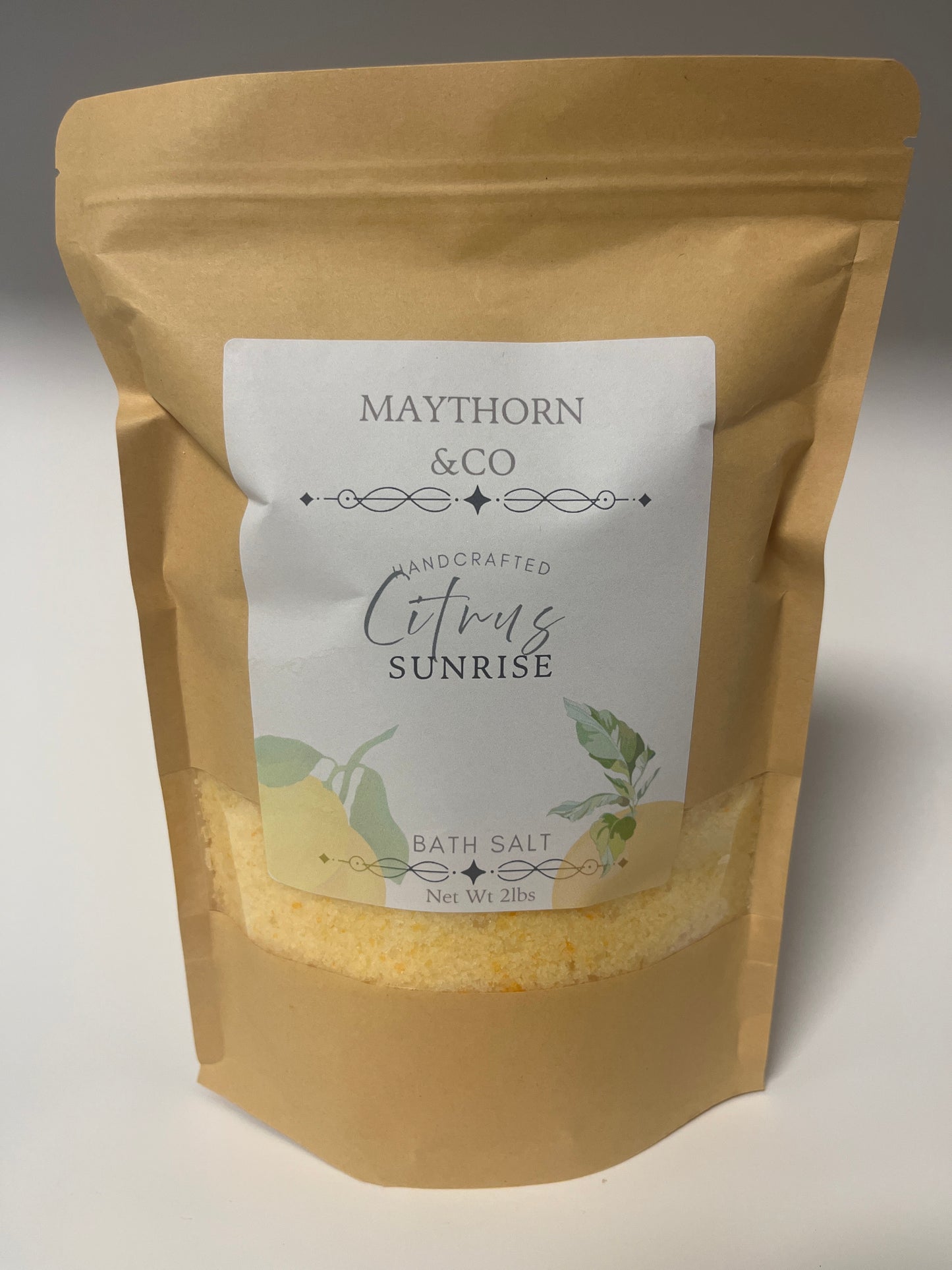 Maythorn & Co Citrus Sunrise Bath Salt in a clear jar with citrus slices and lavender for a relaxing bath experience.
