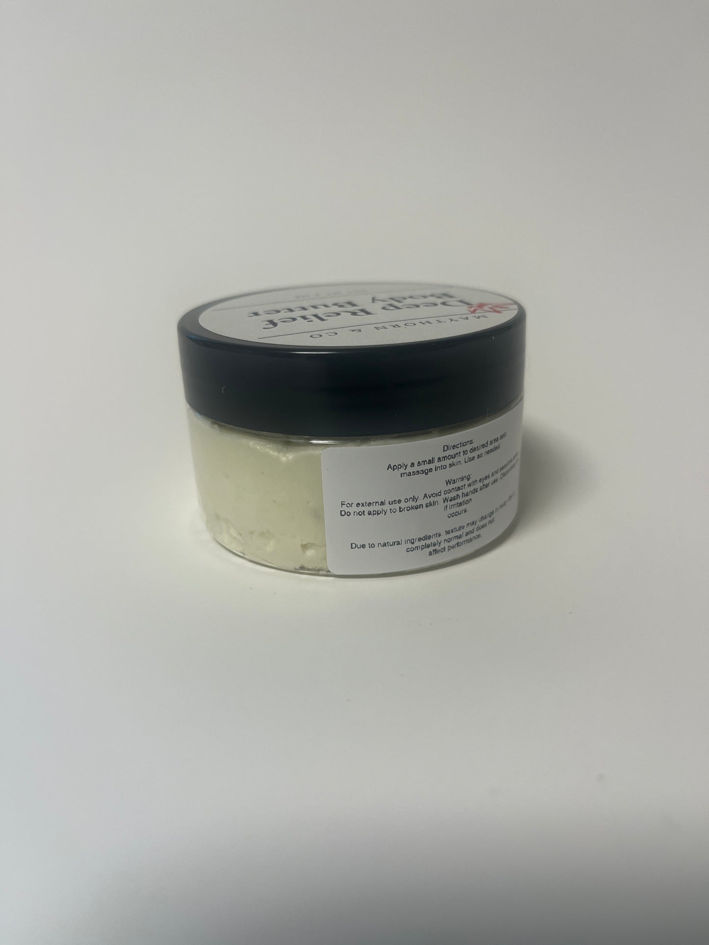 Maythorn & Co Deep Relief Body Butter jar with textured lid and creamy body butter inside.