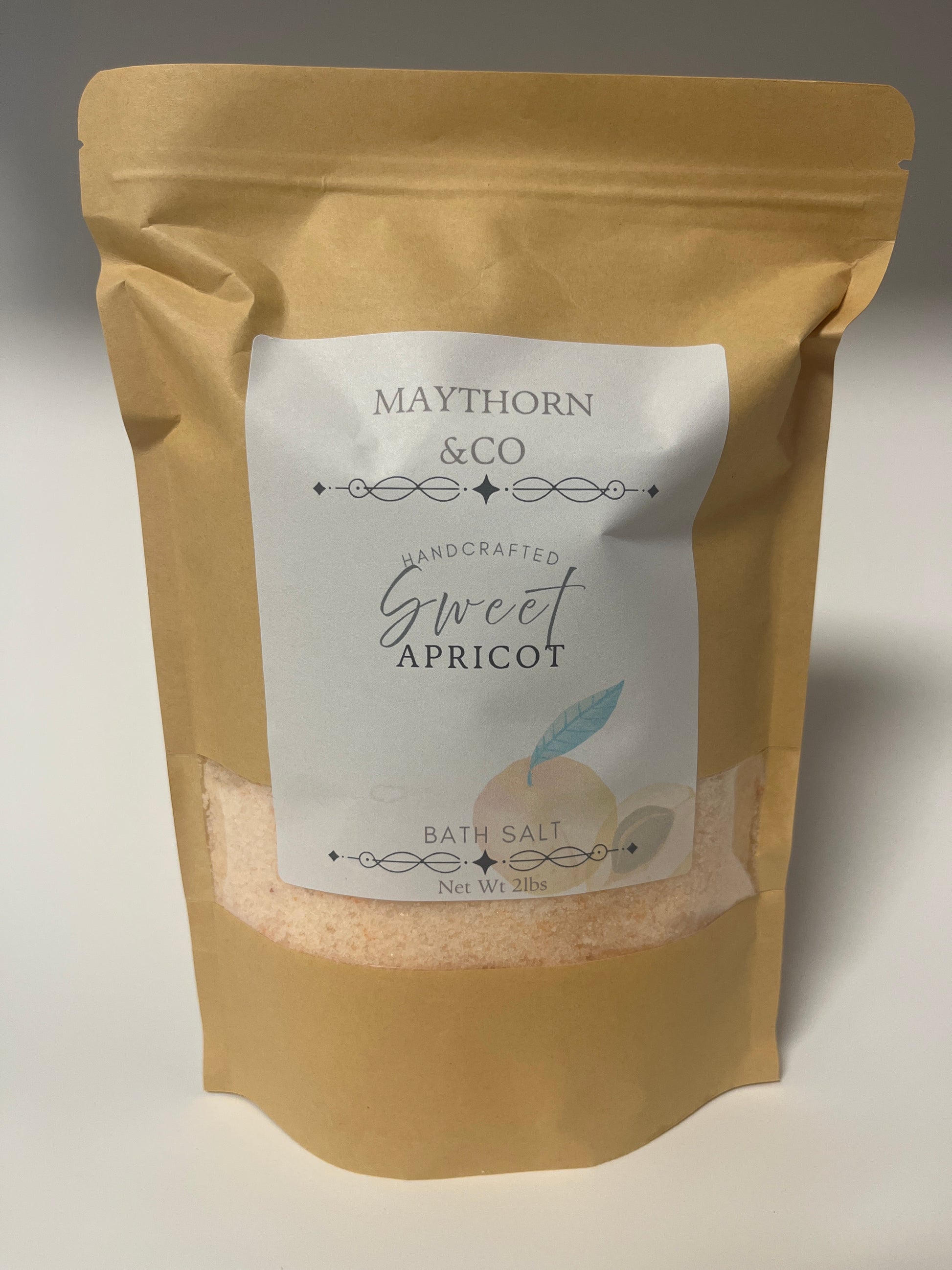 Maythorn & Co Sweet Apricot Bath Salt in a clear jar, showcasing peach-colored salt with apricot pieces for soothing bath relaxation.