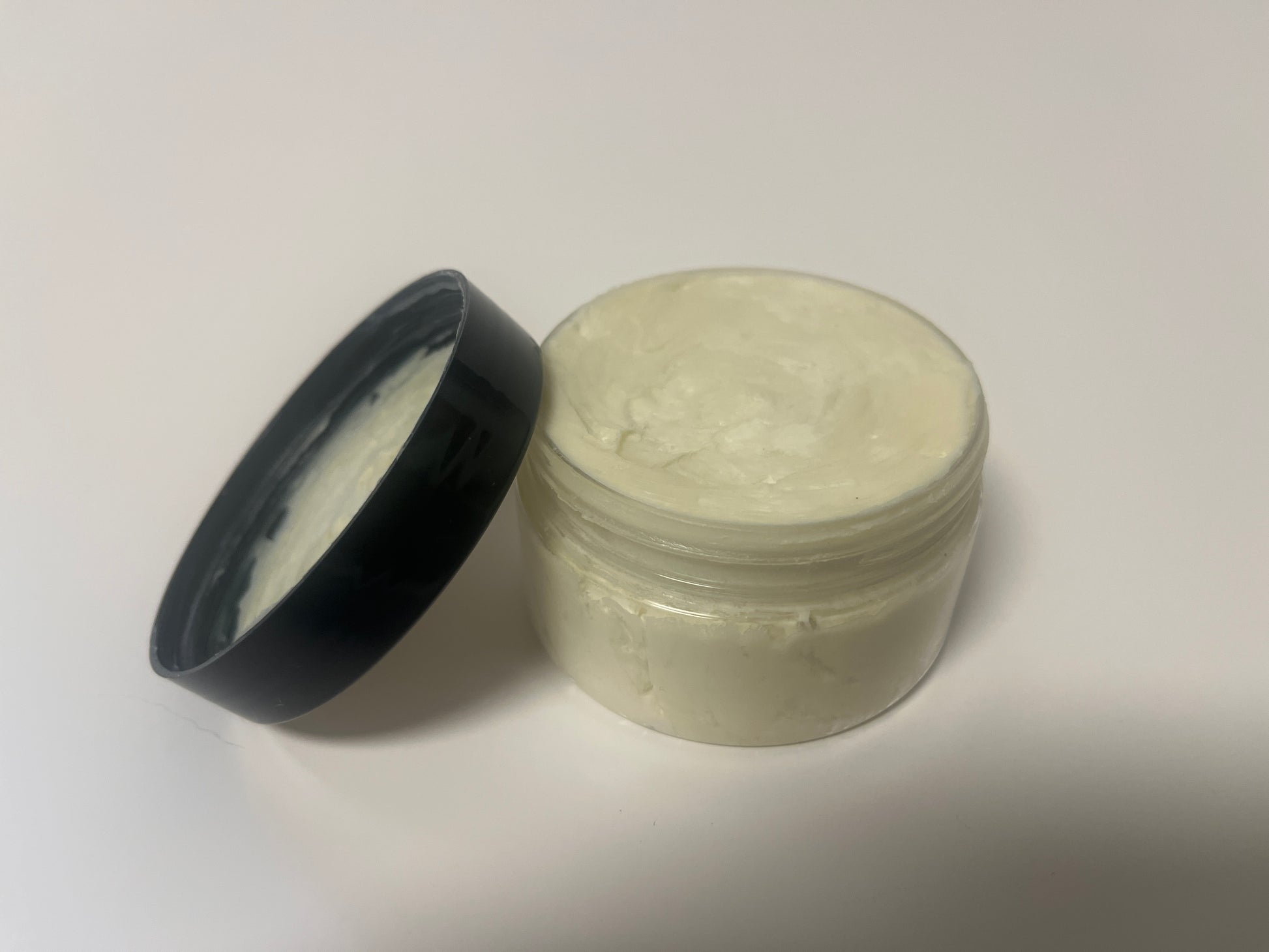 Maythorn & Co Deep Relief Body Butter jar with creamy texture and natural ingredients on a neutral background.