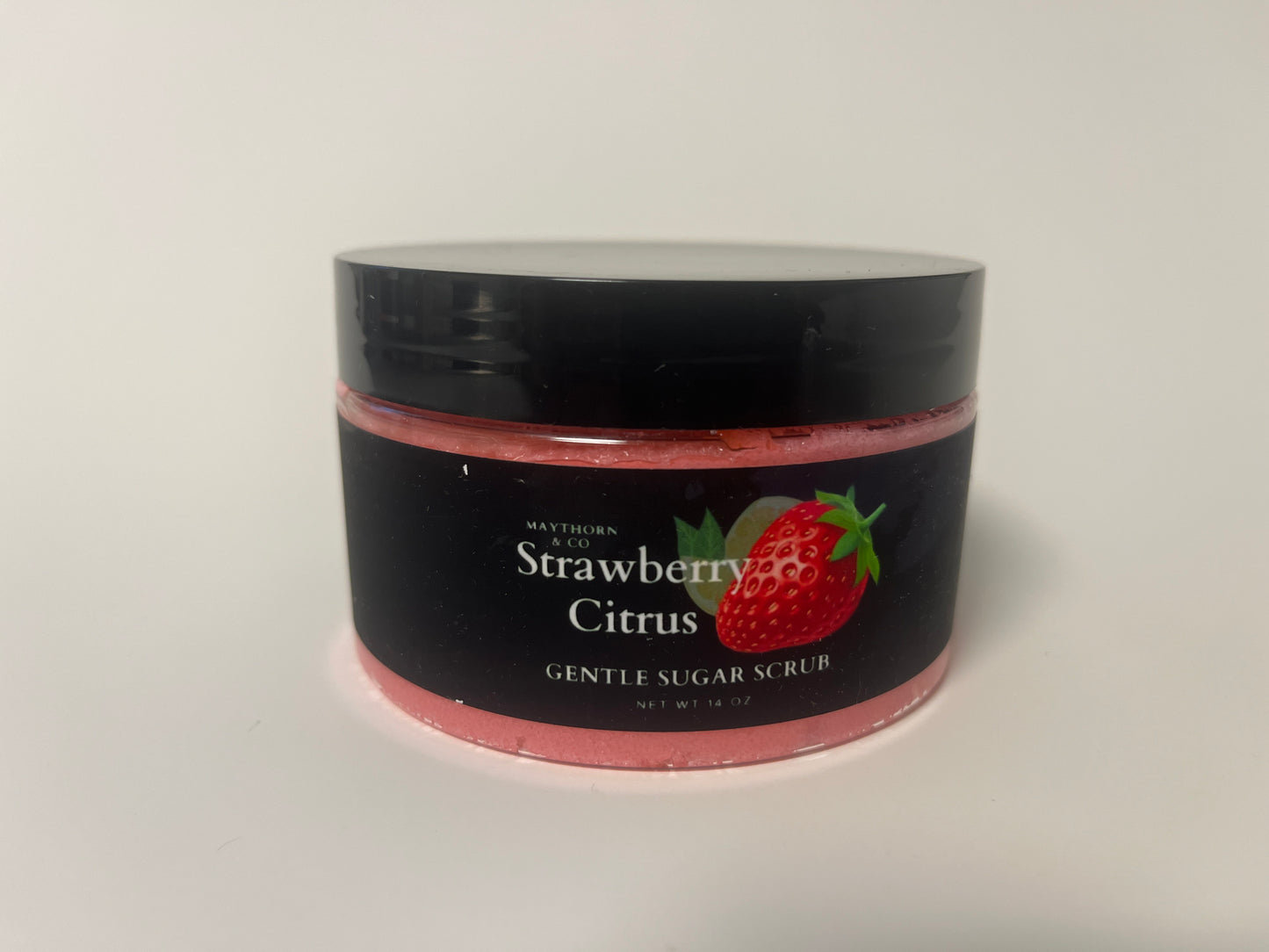 Maythorn & Co Strawberry Citrus Body Scrub with fresh strawberries and citrus slices in a jar, ready for skincare.